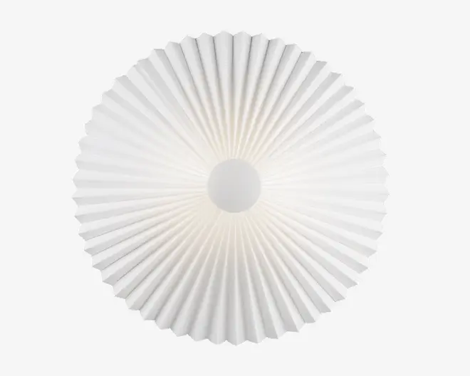 Et rundt, hvidt objekt med en plisseret, vifteformet tekstur, der stråler ud fra midten. Overfladen har jævnt fordelte riller, som danner et solstrålemønster. Materialet virker let og uigennemsigtigt med et glat, cirkulært centrum.