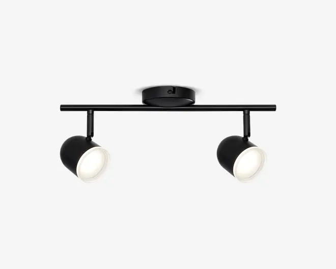 Moderne loftmonteret armatur med to justerbare spotlys. Armaturet har en mat sort finish, en rund base og en lige, vandret stang, der bærer lamperne. Hver spot har en cylindrisk form og kan vinkles individuelt for at rette lyset, hvor det ønskes. Lampeskærmenes inderside er hvid, hvilket forbedrer lysrefleksionen.