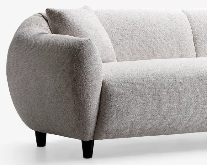 Buet armlæn og ryglæn med blødt, tekstureret lysebeige betræk. Sædet er bredt og polstret for ekstra komfort, og sofaen står på korte, koniske sorte ben. Inkluderer en matchende, firkantet pude for ekstra støtte.