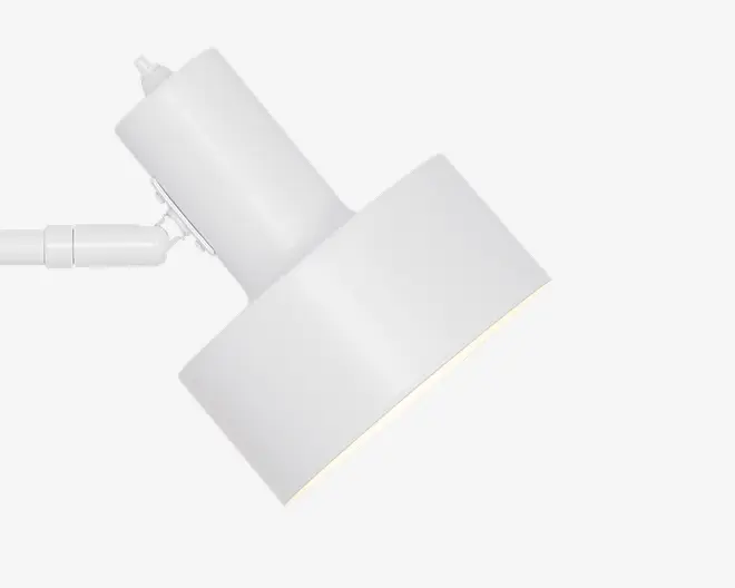 En moderne, minimalistisk hvid spotlampe med cylindrisk lampehus og et rektangulært, let vinklet skærm. Lampen har en glat, mat overflade og et drejeled, så lysets retning kan justeres. Designet er stilrent og diskret, velegnet til moderne indretning.