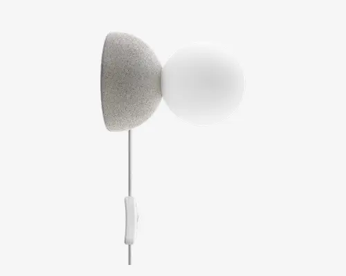 Væghængt lampe med en rund, gråmeleret base og en glat, mat glasglobeskærm. Lampen har en synlig hvid ledning med en afbryder på ledningen for nem betjening. Designet er moderne og minimalistisk, velegnet til nutidige indretninger.