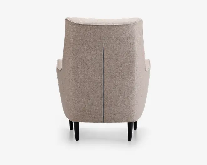 Billedet viser bagsiden af en stol betrukket med lysebeige stof. Stolen har en diskret lodret syning ned langs midten af ryglænet, hvilket giver et elegant detaljepræg. Siderne er let buede, og stolen står på fire koniske, mørke træben.