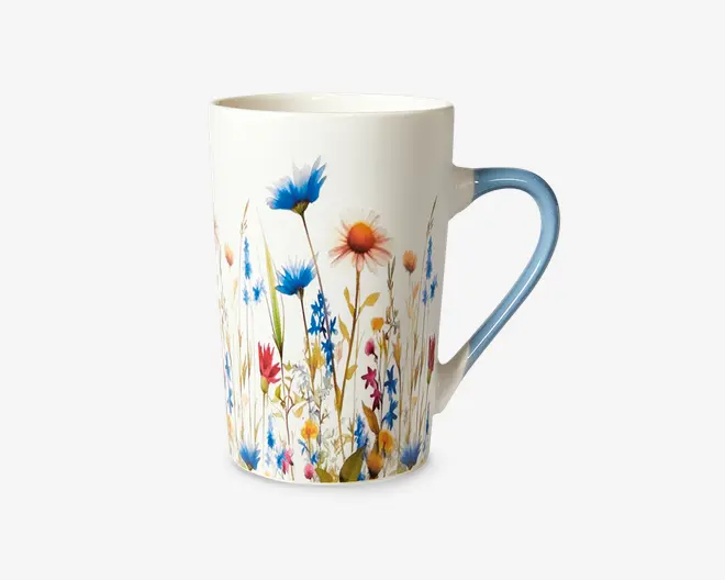 Høj keramikkop med hvid baggrund og et farverigt design af vilde blomster. Blomsterne er i blå, rød, gul og orange nuancer med grønne stilke og blade, hvilket giver et livligt og naturligt udtryk. Hanken er let buet og har en blød overgang til lyseblå, som matcher blomsterdekorationen.