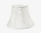 En klokkeformet lampeskærm lavet af hvidt stof med et diskret tekstureret mønster. Skærmen har lodrette stofpaneler adskilt af tynde kantbånd og en bred åbning i bunden samt en smallere åbning i toppen. Det samlede design er klassisk og elegant, velegnet til både traditionel og moderne indretning.