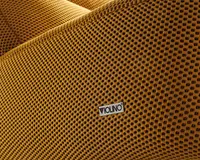 Nærbillede af et tekstureret stof i sennepsgul med et gitterlignende mønster, hvor der er fastgjort et lille rektangulært mærke med teksten 'VIOLINO'. Stoffet ser blødt ud og har en let hævet overflade, hvilket giver en taktil og visuelt interessant finish.