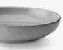 En rund, lav skål med en glat, mat lysegrå yderside og en blank lysegrå inderside. Skålen har en let hævet kant med en diskret, mørkere grå kant. Designet er minimalistisk og moderne med rene linjer og en blødt buet profil.