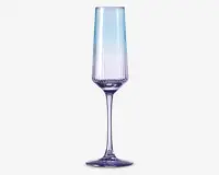 Høj, slank glas med et facetslebet, geometrisk design og en diskret farvegradient, der går fra klar øverst til en lys lilla nuance ved bunden. Glasset har en lang, elegant stilk og en solid, rund fod, hvilket giver det et moderne og sofistikeret udseende.