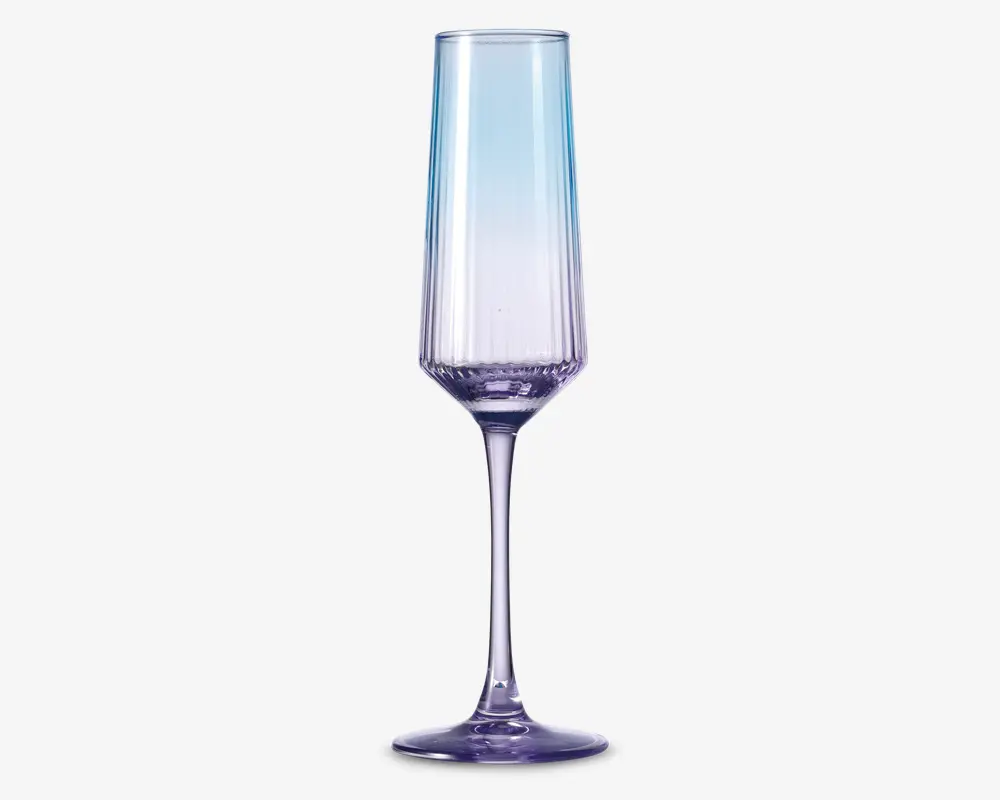 Høj, slank glas med et facetslebet, geometrisk design og en diskret farvegradient, der går fra klar øverst til en lys lilla nuance ved bunden. Glasset har en lang, elegant stilk og en solid, rund fod, hvilket giver det et moderne og sofistikeret udseende.