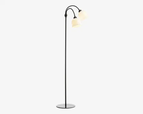 Høj gulvlampe med en slank sort metalstang og en rund, stabil fod. Lampen har to buede arme øverst, som hver holder en hvid, kuppelformet lampeskærm, der giver et blødt lys. Designet er moderne og minimalistisk, velegnet til nutidige indretninger.