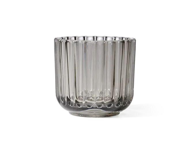 Klar glasbeholder med cylindrisk form og lodret rillet struktur langs siderne. Glasset har en tyk, solid bund og en bred åbning foroven. Det rillede design giver et dekorativt og taktilt udtryk, hvilket gør det velegnet til både funktionel og dekorativ brug.