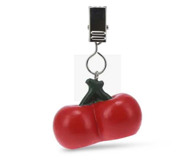 En dekorativ klemme med en realistisk, blank rød tomatcharm med grøn stilk. Tomaten er fyldig og let hjerteformet, fastgjort til en robust sølvfarvet metalklemme via en lille ring, velegnet til at sætte på tasker, tøj eller andre accessories.