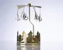 Et dekorativt ornament i metal med en rund base, der er udsmykket med udskårne grantræer. Over basen er der en lodret stang, som bærer et roterende karrusel med hængende vedhæng formet som juletræer. Hele ornamentet er lavet af blankt guldfarvet metal, hvilket giver et festligt og elegant udtryk. Karrusellen er designet til at dreje rundt, sandsynligvis drevet af varme fra stearinlys placeret i bunden (ikke vist på billedet).