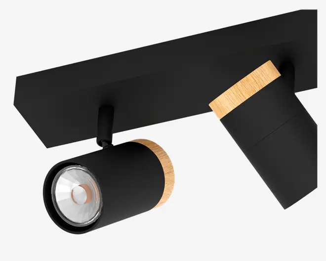 Et moderne loftspotlys med to justerbare cylindriske hoveder i mat sort finish. Hver spot har en naturlig trædetalje ved basen, som giver et varmt præg til det stilrene design. Lampen er monteret på en rektangulær sort base, og spotlysene kan rettes i forskellige retninger for fleksibel belysning.