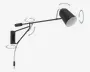 Moderne vægmonteret lampe med mat sort finish, der har en justerbar arm med flere drejepunkter for fleksibel placering. Lampens hoved er konisk og kan drejes for at rette lyset efter behov. Designet inkluderer en slank, minimalistisk monteringsplade og en synlig ledning med en indbygget kontakt.