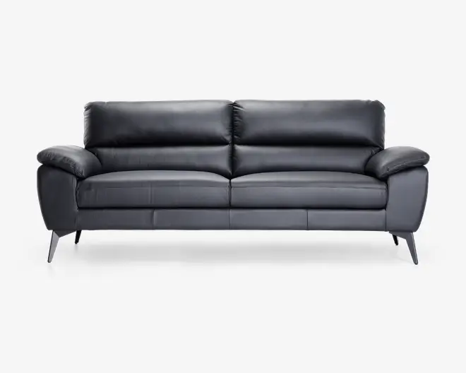 Elegant, moderne sofa betrukket med glat sort læder og bløde, fyldige ryg- og sædehynder for ekstra komfort. Sofaen har brede, polstrede armlæn og let skrå, koniske ben i mørk finish, hvilket giver et moderne udtryk. Syningerne er diskrete og rene, hvilket understreger det minimalistiske design.