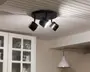 Loftmonteret lampearmatur med tre justerbare spotlys i mat sort finish. Hvert spotlys kan rettes individuelt, hvilket giver mulighed for tilpassede lysvinkler. Armaturet har en rund base, der sidder tæt mod loftet, og spotlysene har et moderne, cylindrisk design med metalliske detaljer for enderne.