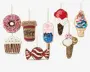 Sæt med otte dekorative ornamenter formet som forskellige søde sager, herunder en lyserød donut, en kaffekop, en cupcake med hvid glasur og farverige krymmel, et rød- og hvidstribet slik, en ispind med lyserøde og blå farver, en isvaffel med rød og hvid kugle, en softice-vaffel med blå, lyserøde og hvide striber samt en isvaffel med hvid og lyserød kugle. Hver ornament er pyntet med pailletter og perler, hvilket giver dem et glitrende og tekstureret udseende. Alle har gyldne ophængsløkker til nem udstilling.