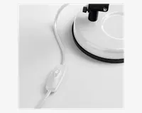 Nærbillede af en hvid, rund base med sort kant, der har en strømledning med en indbygget tænd/sluk-knap. Kontakten er oval og har samme farve som ledningen, hvilket gør den nem at betjene.