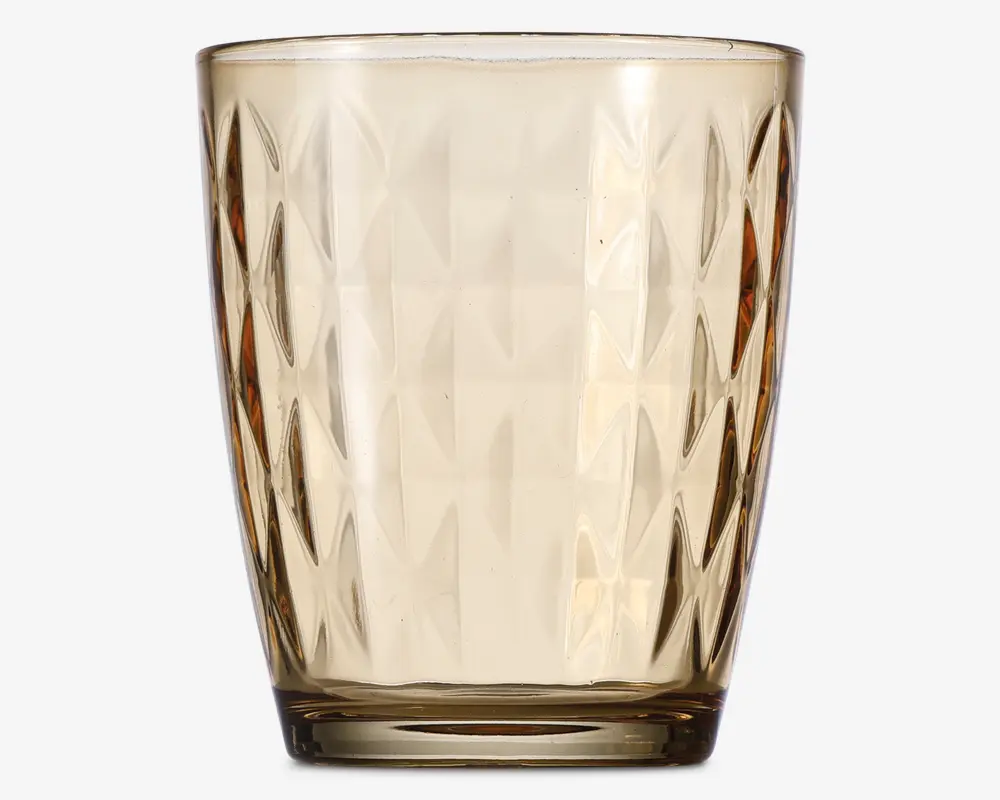 Et transparent drikkeglas med en let ravfarvet tone, der har en geometrisk diamantmønstret tekstur på ydersiden. Glasset er let konisk, bredere foroven og smallere ved bunden, med en glat kant og en tyk, solid bund for stabilitet.