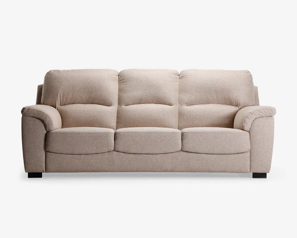 En tresæders sofa betrukket med lysebeige stof, der har bløde, fyldige ryg- og sædehynder for ekstra komfort. Armlænene er brede og polstrede, hvilket giver ekstra støtte. Sofaen har et moderne design med rene linjer og står på korte, solide sorte ben.