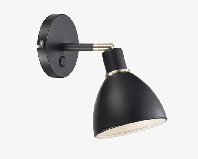 Væghængt lampe i mat sort med konisk skærm og rund base. Lampen har en børstet metal-detalje ved samlingen og en indbygget tænd/sluk-knap på basen. Skærmens inderside er hvid for bedre lysrefleksion. Lampens hoved kan justeres for retningsbestemt belysning.