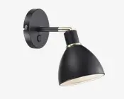 Væghængt lampe i mat sort med konisk skærm og rund base. Lampen har en børstet metal-detalje ved samlingen og en indbygget tænd/sluk-knap på basen. Skærmens inderside er hvid for bedre lysrefleksion. Lampens hoved kan justeres for retningsbestemt belysning.