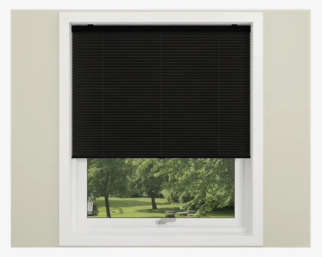 Sort plisseret vinduesafdækning, delvist sænket, med jævnt fordelte vandrette folder for et moderne udtryk. Materialet virker uigennemsigtigt og giver privatliv samt lysblokering. Gardinet passer pænt ind i en hvid vinduesramme og har et glat, minimalistisk design uden synlige snore eller beslag.