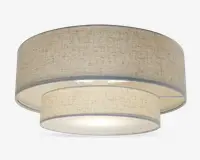 Et moderne loftarmatur med dobbelt tromledesign bestående af to koncentriske stofskærme i en neutral beige farve. Den ydre skærm er større og omgiver en mindre indre skærm, begge med et diskret tekstureret mønster. Bunden er dækket af en mat diffuser, der giver et blødt og jævnt lys. Armaturet har et rent, moderne udtryk, der passer til mange forskellige indretninger.