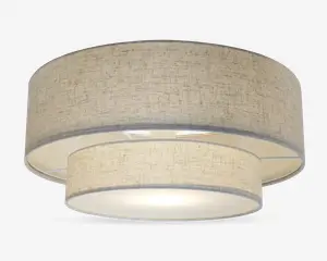 Et moderne loftarmatur med dobbelt tromledesign bestående af to koncentriske stofskærme i en neutral beige farve. Den ydre skærm er større og omgiver en mindre indre skærm, begge med et diskret tekstureret mønster. Bunden er dækket af en mat diffuser, der giver et blødt og jævnt lys. Armaturet har et rent, moderne udtryk, der passer til mange forskellige indretninger.