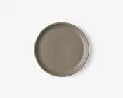 Rund tallerken med en glat, mat overflade i taupe farve. Tallerkenen har en let forhøjet kant og et minimalistisk, moderne design uden mønstre eller dekorationer.
