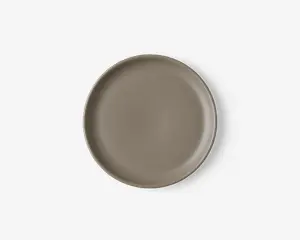 Rund tallerken med en glat, mat overflade i taupe farve. Tallerkenen har en let forhøjet kant og et minimalistisk, moderne design uden mønstre eller dekorationer.