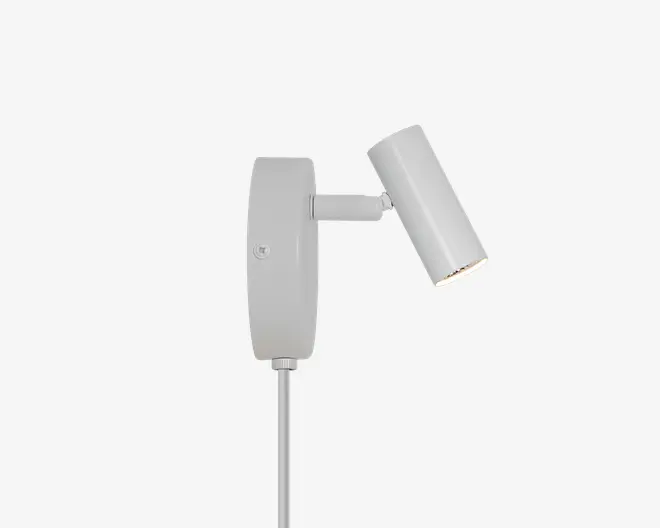 Mat lysegrå justerbar spotlampe med rektangulær vægmontering, kort vandret arm og vinklet цилиндrisk lampehoved.