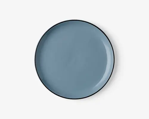 Rund tallerken med en glat, blank overflade i en afdæmpet blå farve. Kanten er tynd og let hævet med en diskret mørkere kant. Overfladen er jævn og uden tekstur, hvilket giver et moderne og minimalistisk udtryk.