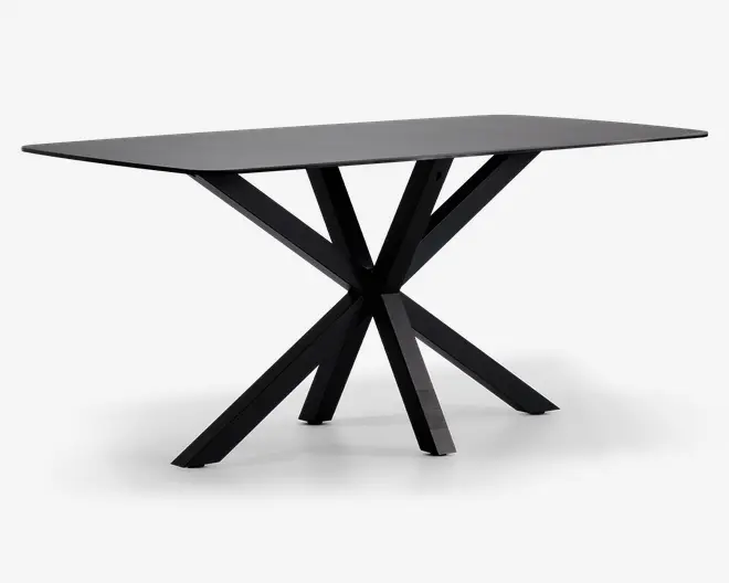 Rektangulært bord med mat sort finish, tyk og flad bordplade samt et karakteristisk geometrisk stel bestående af flere skråtstillede ben, der mødes i midten og giver et moderne, skulpturelt udtryk.