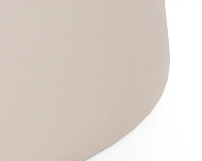 Nærbillede af en glat, mat overflade i en lys beige farve med en afrundet, let ujævn kant. Materialet ser blødt og fleksibelt ud, muligvis lavet af syntetisk eller naturligt stof. Farven er ensartet og neutral, hvilket gør den nem at matche med forskellige indretninger.