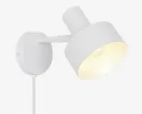 En moderne vægmonteret lampe med mat hvid finish. Lampen har en cylindrisk skærm, der kan vinkles for justerbar lysretning. Den har en rund baseplade til sikker montering på væggen og en synlig ledning, der går ud fra bunden. Designet er minimalistisk og passer godt til moderne indretning.