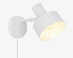 En moderne vægmonteret lampe med mat hvid finish. Lampen har en cylindrisk skærm, der kan vinkles for justerbar lysretning. Den har en rund baseplade til sikker montering på væggen og en synlig ledning, der går ud fra bunden. Designet er minimalistisk og passer godt til moderne indretning.