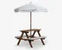 Træ-picnicbord med to fastmonterede bænke og et centralt hul til en stor parasol. Parasollen har en hvid dug med tynde, vandrette, mørkeblå striber. Begge bænke har matchende hvide hynder med mørkeblå striber for ekstra komfort. Bordet og bænkene har en naturlig træfinish og er velegnet til udendørs brug.
