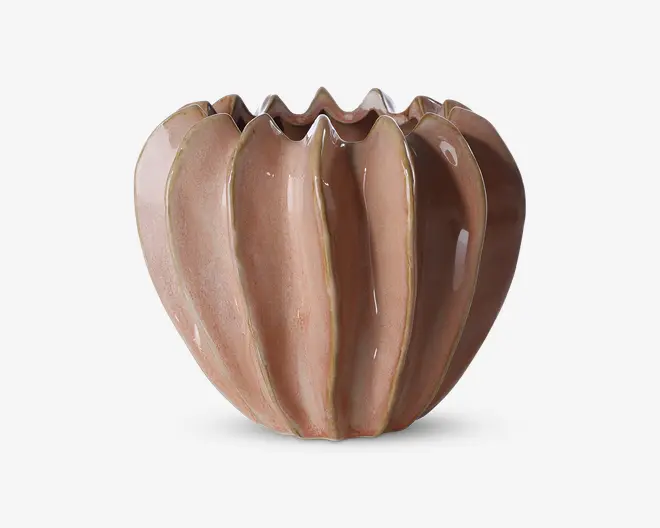 En dekorativ keramisk beholder med en blank, lysebrun glasur. Beholderen har et unikt, bølget design med lodrette riller og en ujævn, bølgende kant, hvilket giver et moderne og kunstnerisk udtryk. Overfladen er glat og reflekterende, og formen er rund og fyldig.