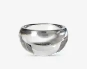 En klar, rund glasskål med tykke vægge og en glat, poleret overflade. Skålen har en bred åbning og en dyb, afrundet bund, hvilket giver den et solidt og elegant udseende. Glassets gennemsigtighed gør det nemt at se indholdet.