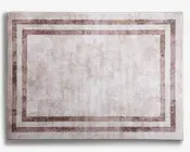 Rektangulært tæppe med en diskret, slidt tekstur i lyse beige nuancer. Designet har to parallelle, mørkere beige kanter, der indrammer tæppet og skaber en lagdelt effekt. Det samlede udtryk er minimalistisk og moderne med en blød, afdæmpet farvepalet, der passer til forskellige indretningsstile.