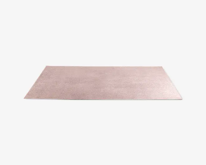 Rektangulært måtte med en diskret, lyserød farve og en fin, tekstureret overflade. Måtten har et minimalistisk design med rene, lige kanter og et ensartet udseende, hvilket gør den velegnet til moderne indretning.
