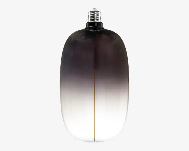 Afrundet glasflaske med mørk, røget sort top, der toner over i klart glas nederst, afsluttet med en sølvfarvet sprayhætte og en smal lodret midterlinje.