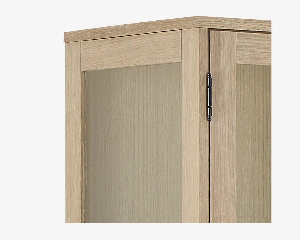 Nærbillede af et skabshjørne med lys egetræsfinish og en glat, flad paneldør. Skabet har et synligt metalhængsel i mørk farve, og træets årer er diskret tekstureret for et naturligt udseende. Designet er enkelt og moderne med rene linjer og en rektangulær ramme.