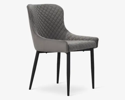 Stol med moderne design og quiltet diamantmønster på ryglæn og sæde. Betrukket med blødt gråt stof, har stolen let buede armlæn og en polstret siddeflade for ekstra komfort. Benene er slanke, lige og har en mat sort finish, hvilket giver et stilrent og nutidigt udtryk.