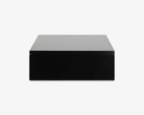 Rektangulær boks med en blank sort front og en mat sølvfarvet top. Designet er minimalistisk med rene linjer og uden synlige knapper, håndtag eller branding på fronten. Boksen fremstår solid og moderne, velegnet til nutidige indretninger.