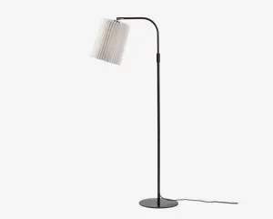 Høj gulvlampe med en slank, sort metalstang og rund fod. Lampen har en hvid, plisseret stofskærm, der hænger skråt fra en buet arm, hvilket giver et moderne og elegant udtryk. Strømkablet er synligt ved lampens fod.