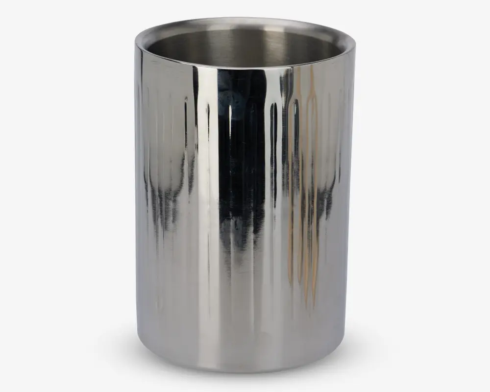 Høj, cylindrisk beholder lavet af poleret rustfrit stål med en reflekterende overflade og diskrete lodrette riller. Den åbne top viser et glat indre, velegnet til opbevaring af flasker eller andre genstande. Designet er moderne og stilrent med fokus på holdbarhed og nem rengøring.