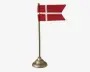 Miniature rødt bordflag med hvidt kors, monteret på en slank metalstang med dekorativ rund fod.