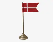 Miniature rødt bordflag med hvidt kors, monteret på en slank metalstang med dekorativ rund fod.